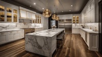 a white kitchen with marble counter tops and gold pendant lights