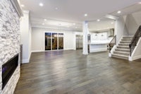 an empty living room with hardwood floors and a fireplace